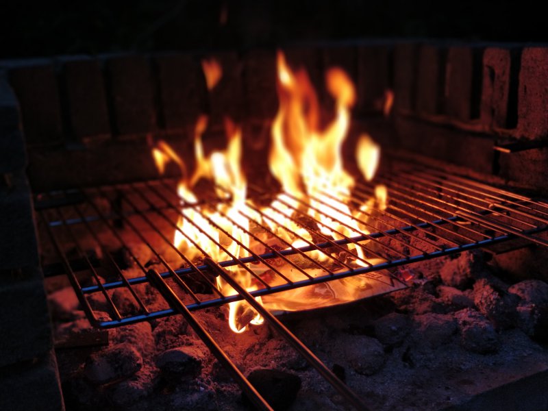 Grillrost über der Flamme ausbrennen.