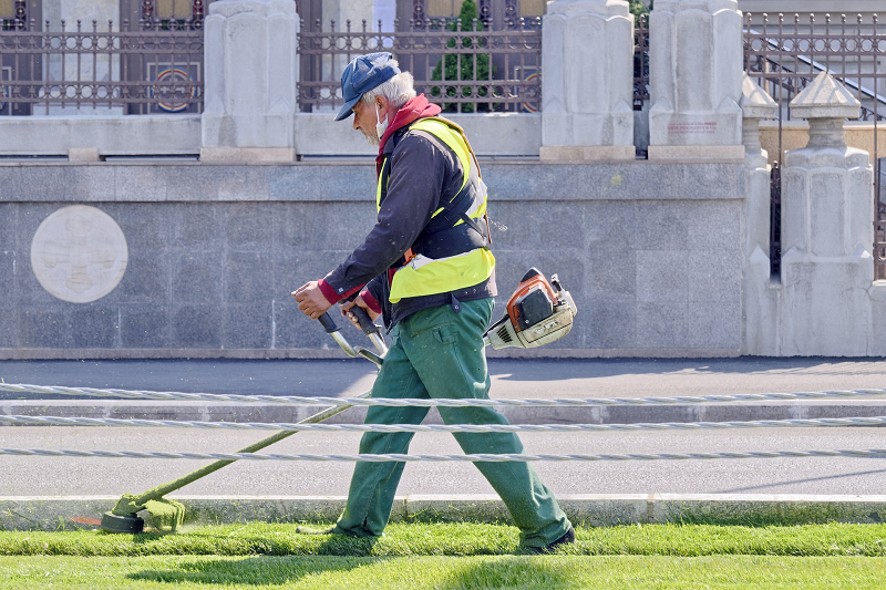 Ein Mann beim Arbeiten mit einem Rasentrimmer