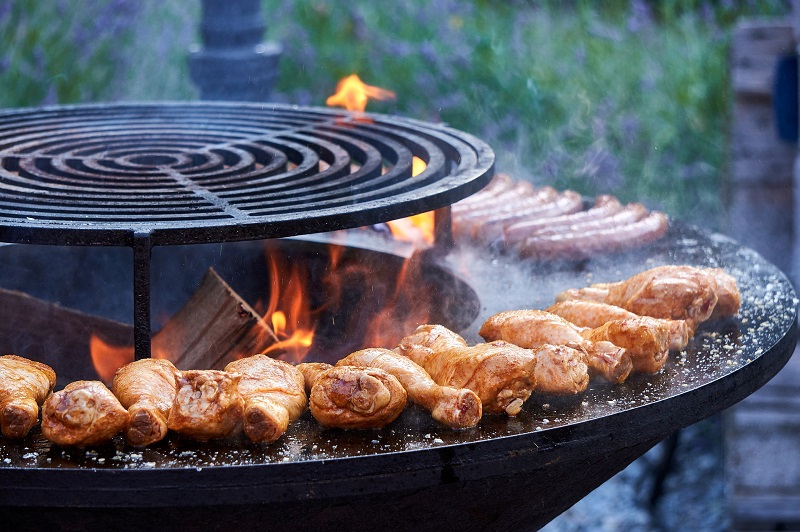 Feuerschale mit Grillrost und Grillring auf dem Fleisch gegrillt wird Feuerschale mit Grillrost und Grillring auf dem Fleisch gegrillt wird