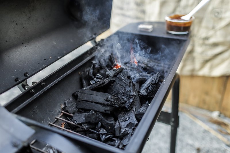 Grill mit Holzkohle Grill mit Holzkohle, die raucht