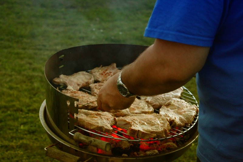 Mann grillt am Säulengrill