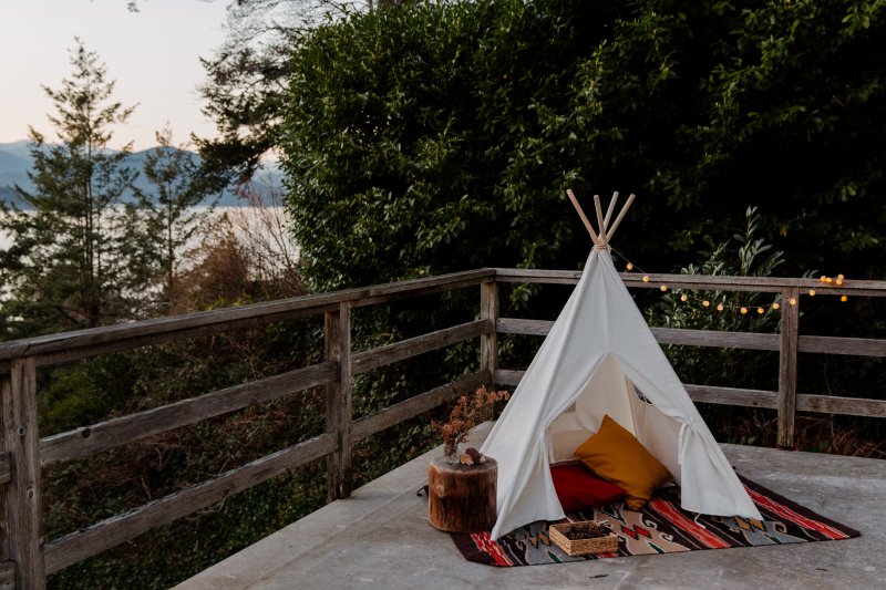 Outdoor Teppich aus umweltfreundlichen Materialien Ein Outdoor Teppich auf einer Terrasse unter einem Indianerzelt