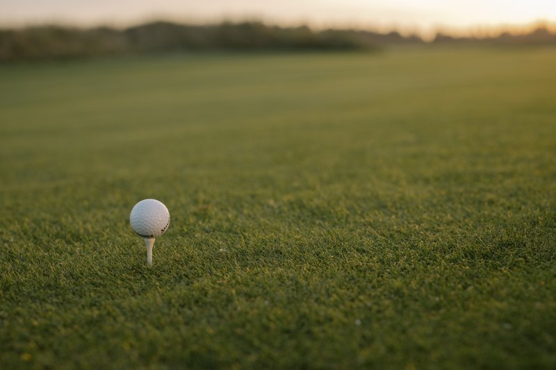 Ein Golfball auf einem kurz gemähten Rasen Ein Golfball auf einem kurz gemähten Rasen