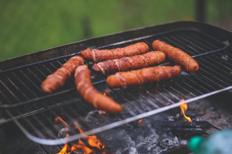 Würstchen werden auf dem Grillrost gegrillt