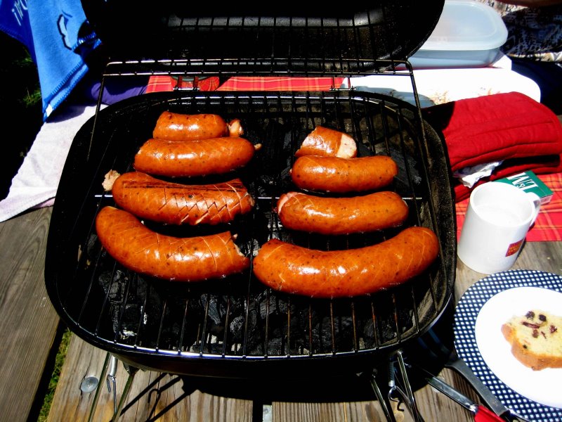 Würstchen garen auf einem Kohle-Tischgrill