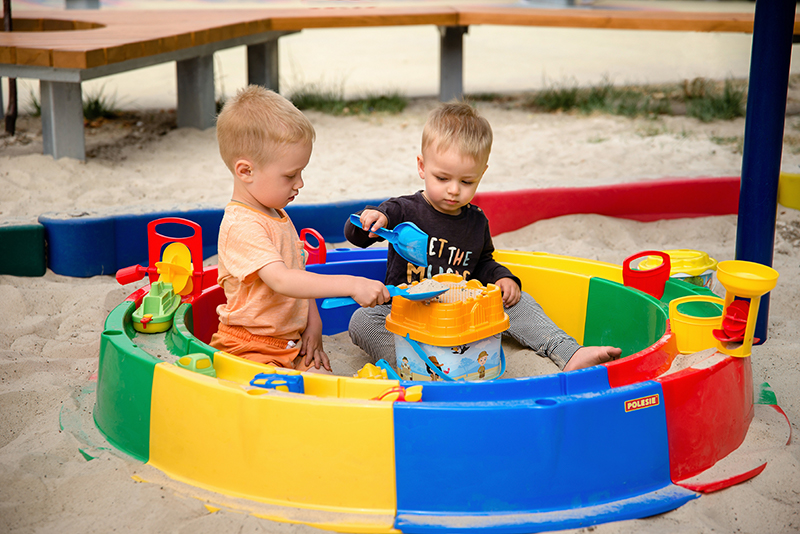 Ein Kunststoffsandkasten mit zwei Kindern darin