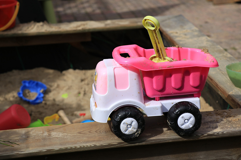 Ein Plastik LWK steht auf einem Holzsandkasten