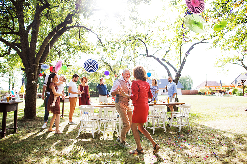 Familie im Garten mit tanzendem Paar Familie im Garten mit tanzendem Paar