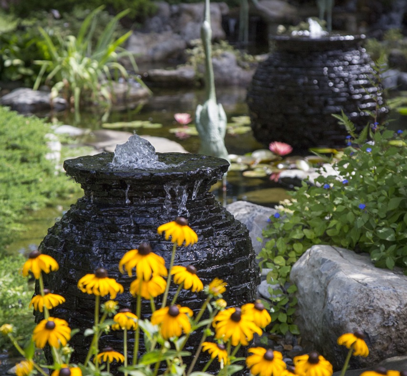 Gartenteich mit Fontaene Gartenteich mit Dekoration und Wasserfontäne