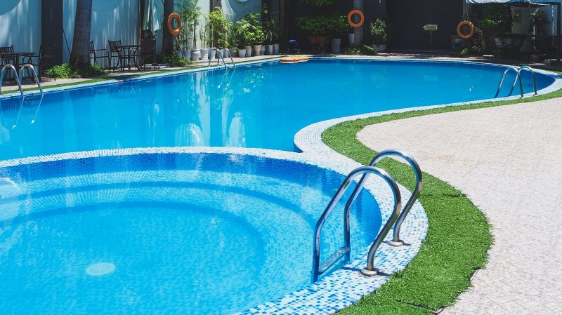 Ein großer Pool mit zwei Poolleitern aus Edelstahl Ein großer Pool mit zwei Poolleitern aus Edelstahl