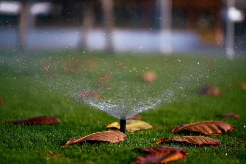 Versenkregner im Rasen Ein Versenkregner beregnet den Rasen im Herbst