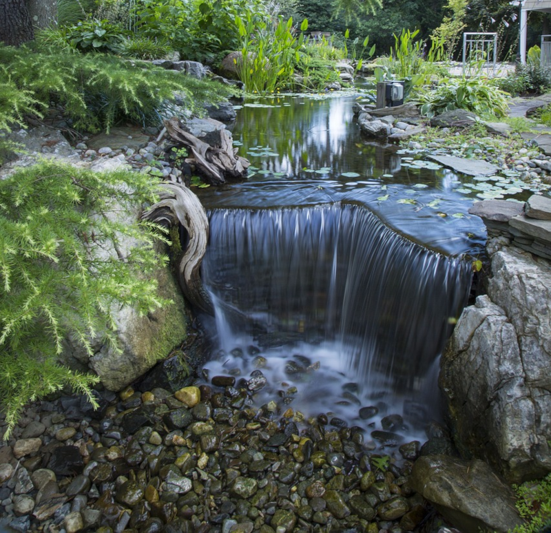 Wasserfall in einem Teich Ein Wasserfall integriert in einem Gartenteich
