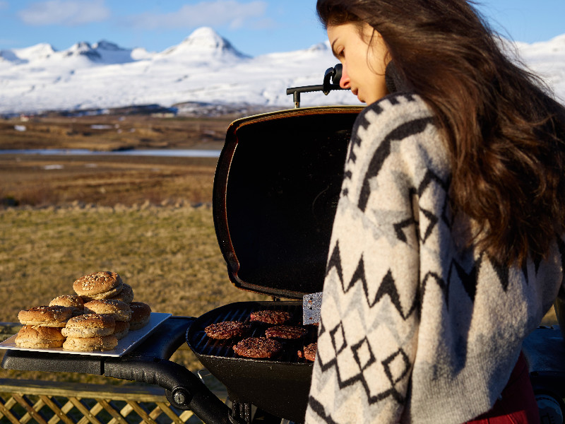 Eine Frau steht vor ihrem Pelletgrill und schaut auf ihr fertiges Fleisch